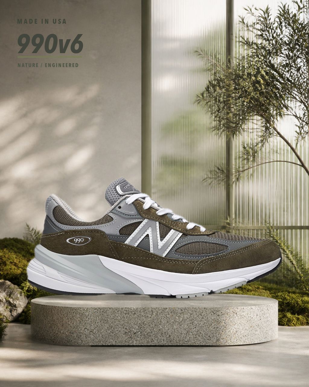 New Balance 990v6 U990OG6 灰橄欖綠跑鞋側面，置於晨光植物溫室的磨石展示台